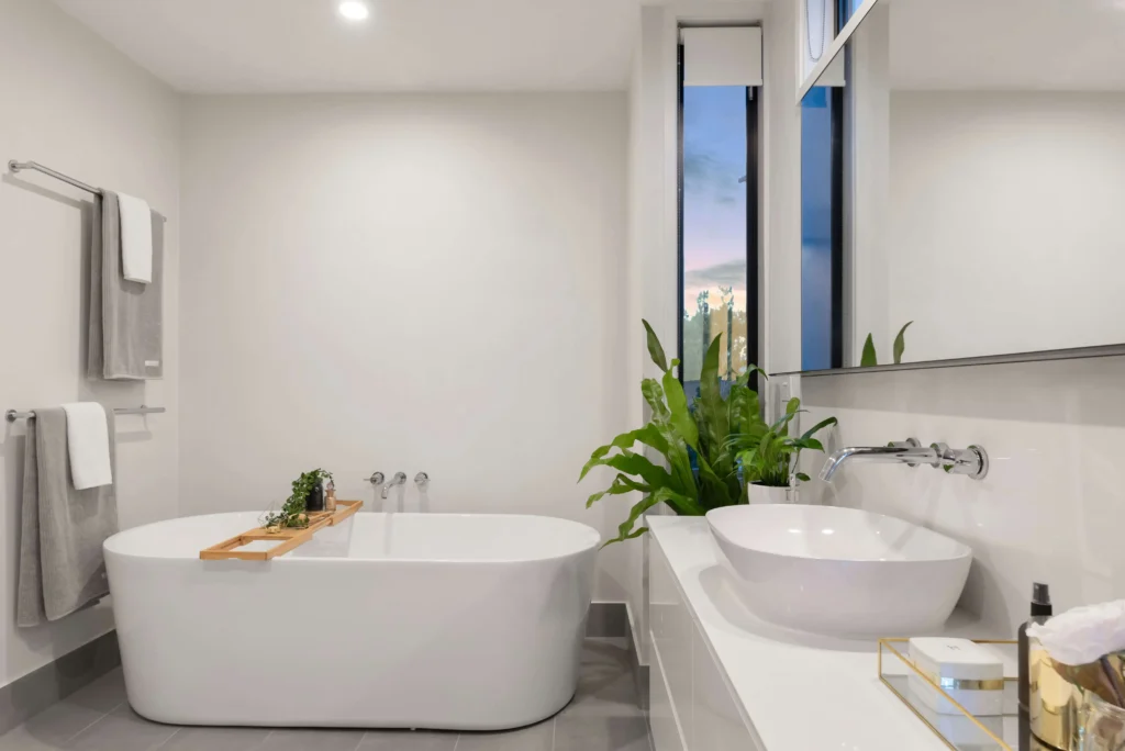 Beautiful bathroom lighting highlighting the curvy white tub and vanity