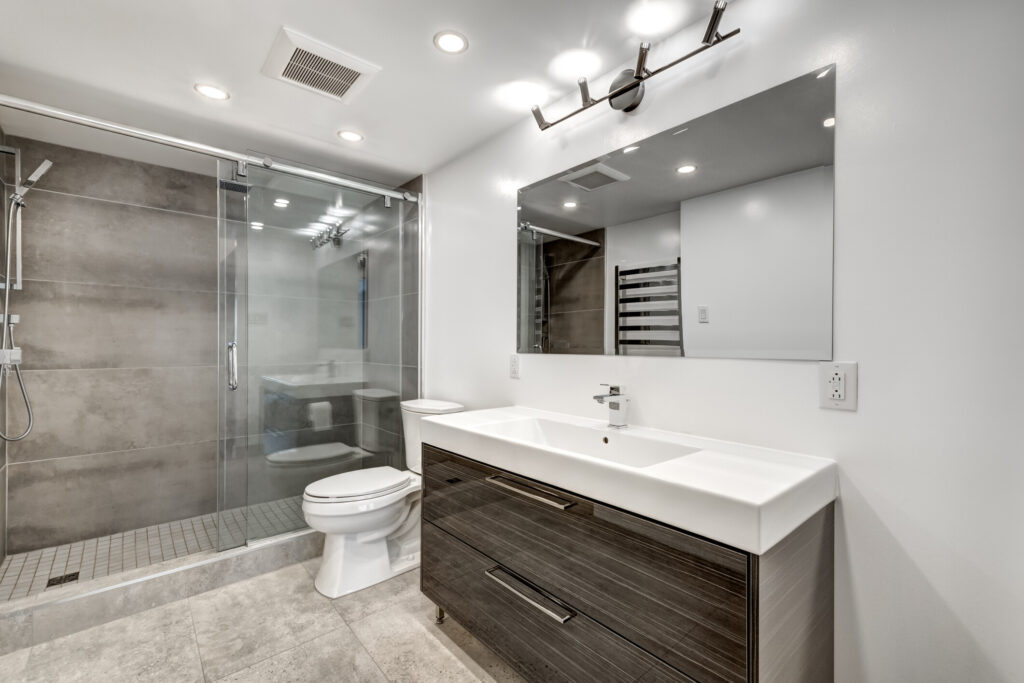 Dark brown bathroom cabinetry with a white vanity and toilet
